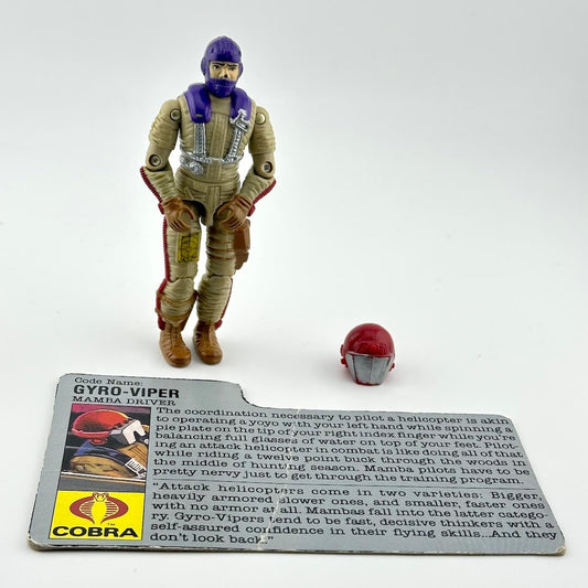Action figure in flight suit with helmet and character card against white background. 