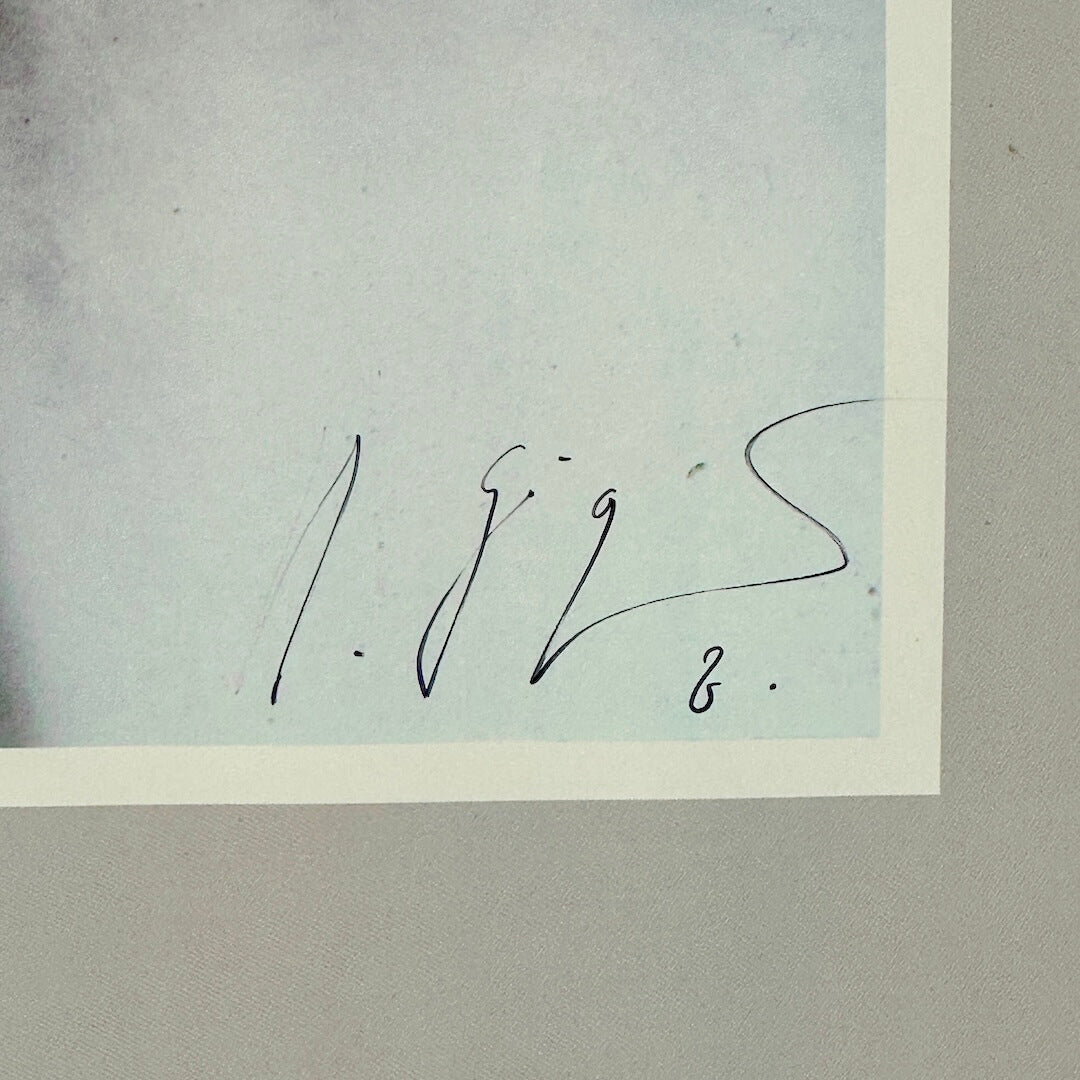Signature on a light blue background with a white border