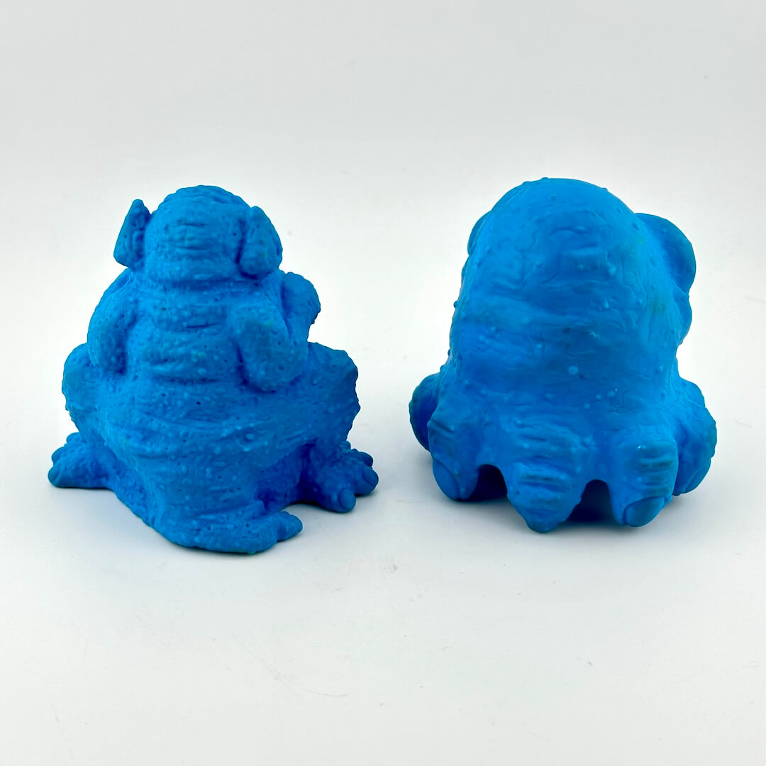 Two blue monster-shaped objects on a white background