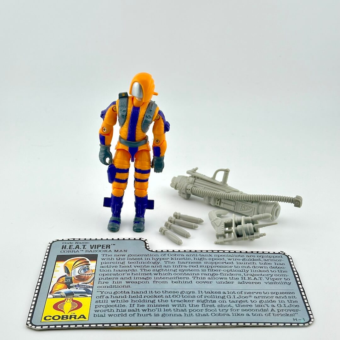 GI Joe action figure with accessories and character card against white background. 
