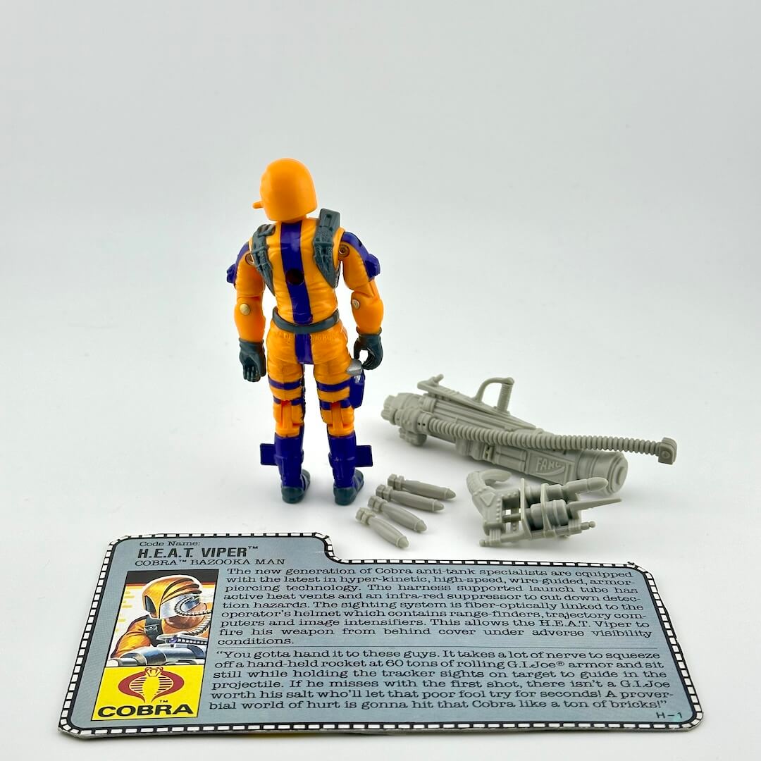 Toy figure of a character in orange and blue with accessories and character card on a white background