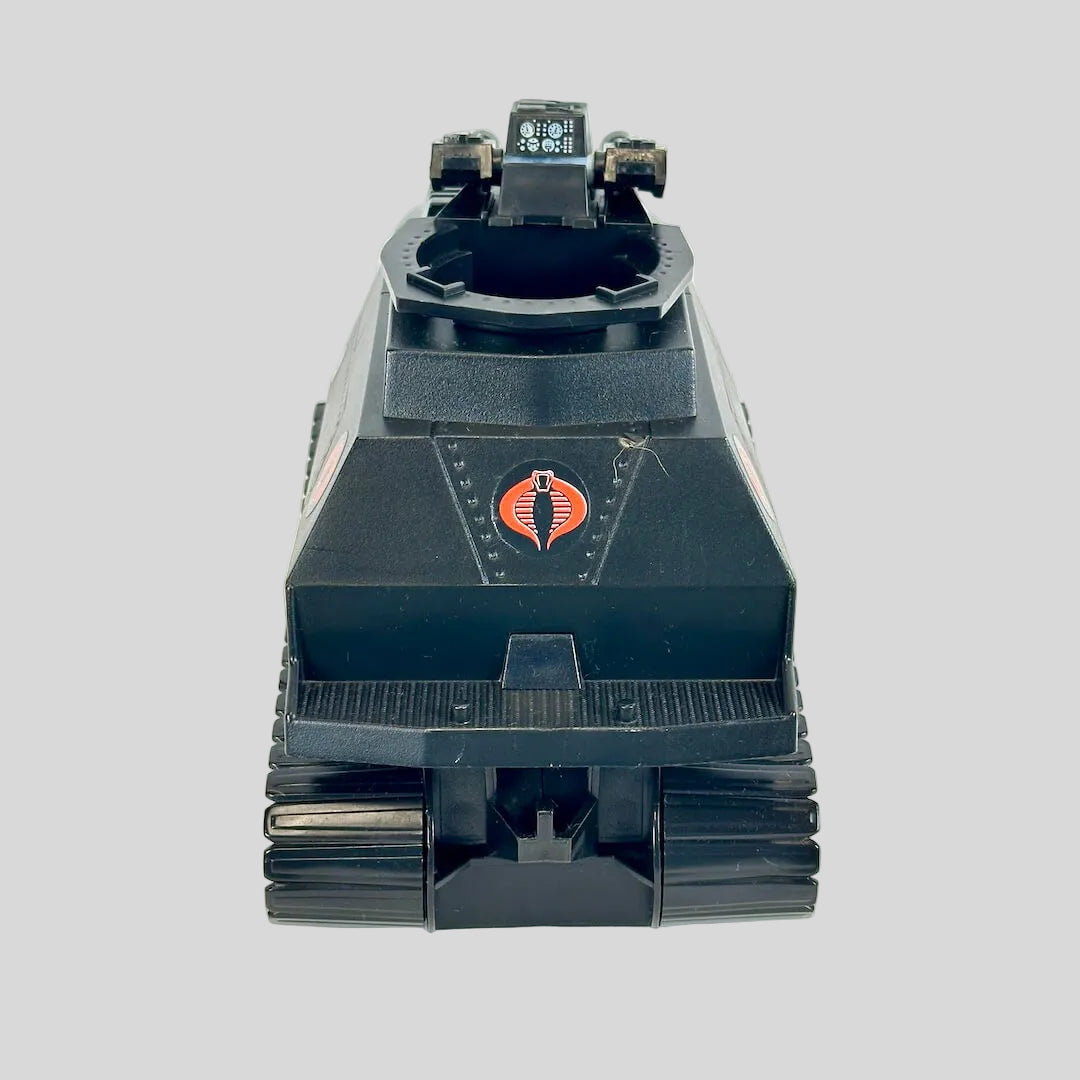 A vintage black plastic toy tank featuring the red and black Cobra logo on the front, photographed against a plain background.