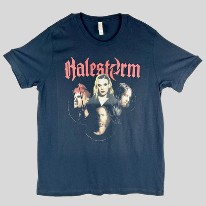 A black short-sleeve graphic t-shirt laid flat, 'Halestorm' in a red gothic font above a circular collage of band members' faces.