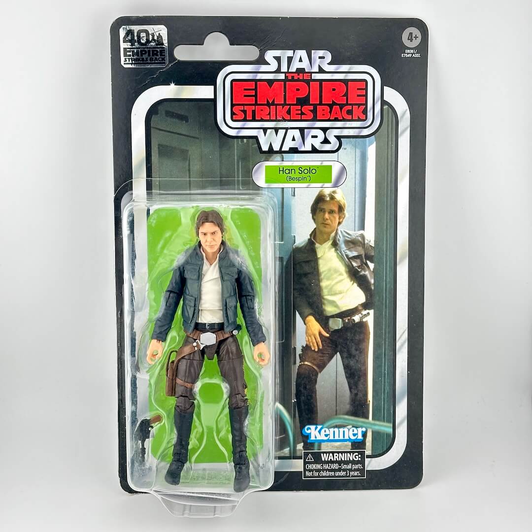 Star Wars action figure in original blister packaging, figure in brown pants and blue jacket with accessory. 