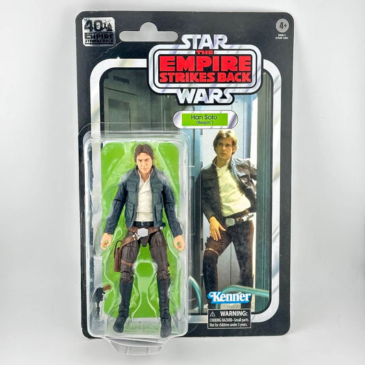 Star Wars action figure in original blister packaging, figure in brown pants and blue jacket with accessory. 