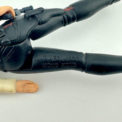 Black gun handle with 'OMELI 1977 HONG KONG' engraving on a white background