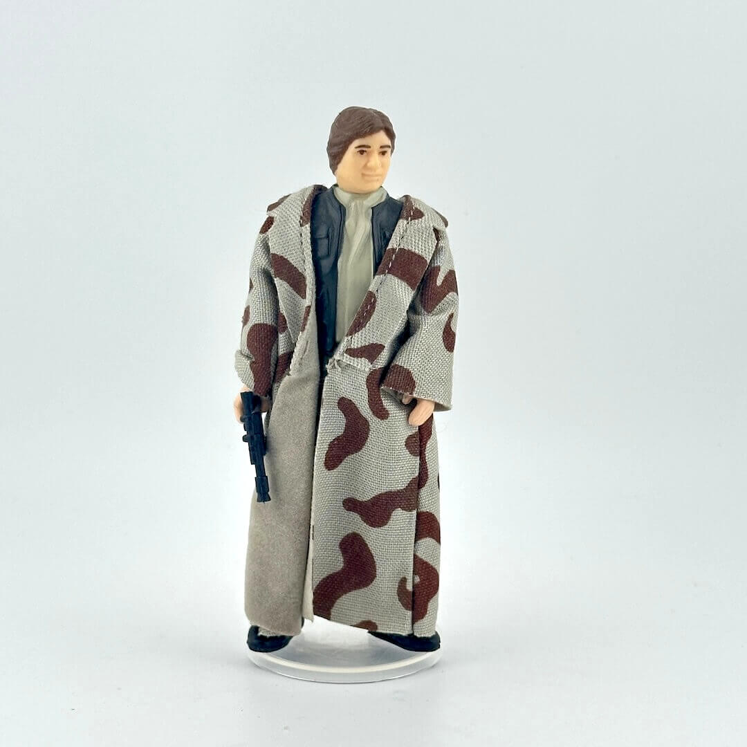Action figure wearing a long coat with camouflage pattern on a white background