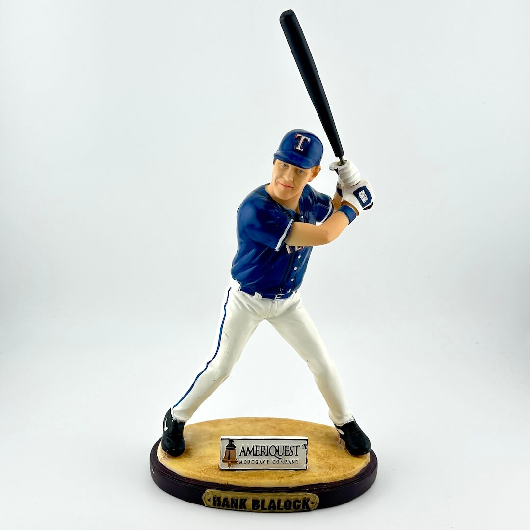 Baseball player figurine holding a bat on a white background