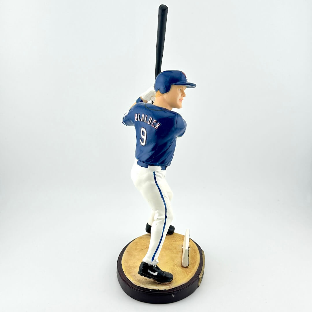 Baseball player figurine in blue uniform with number 9 on a white background