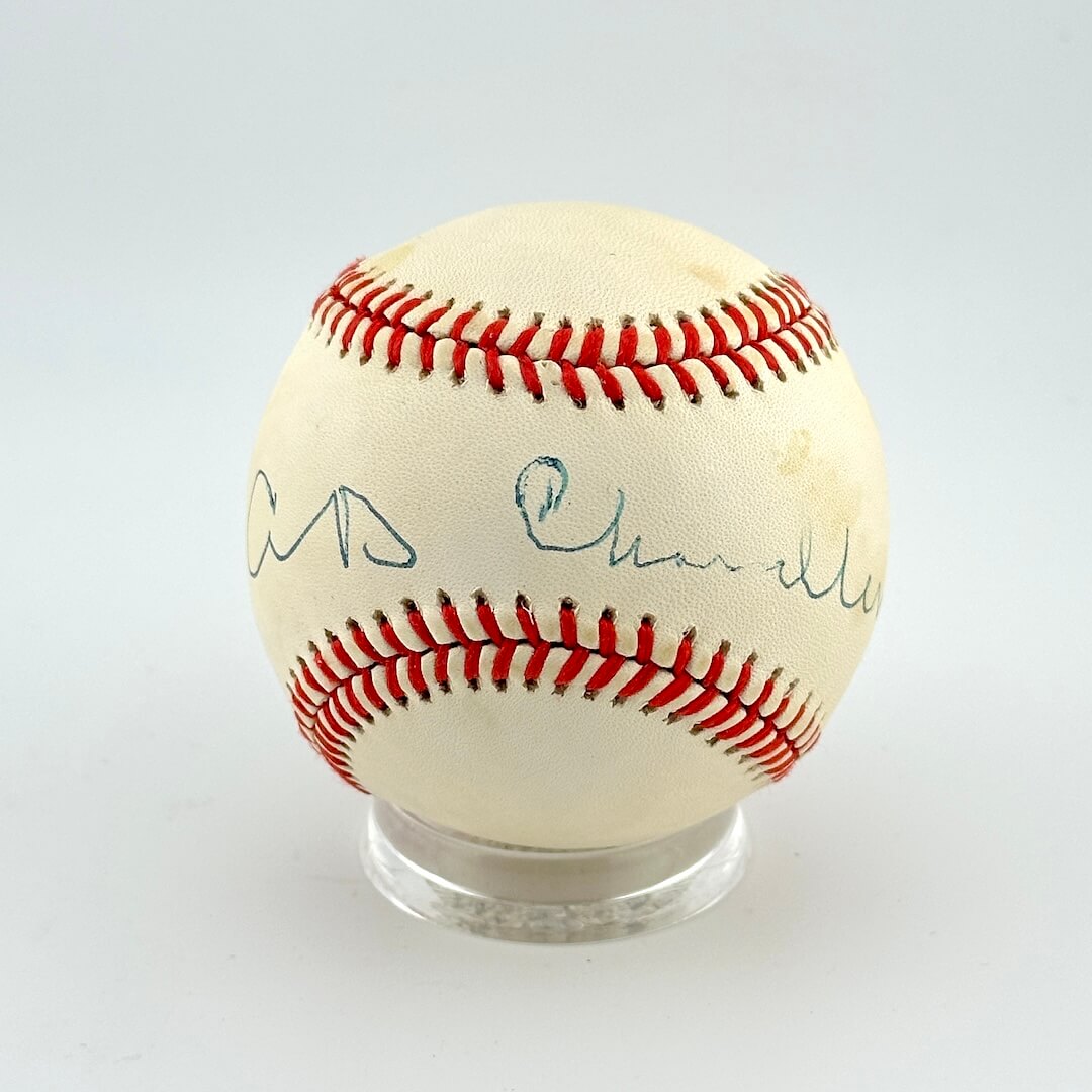 Baseball with autographs on a clear stand against a white background