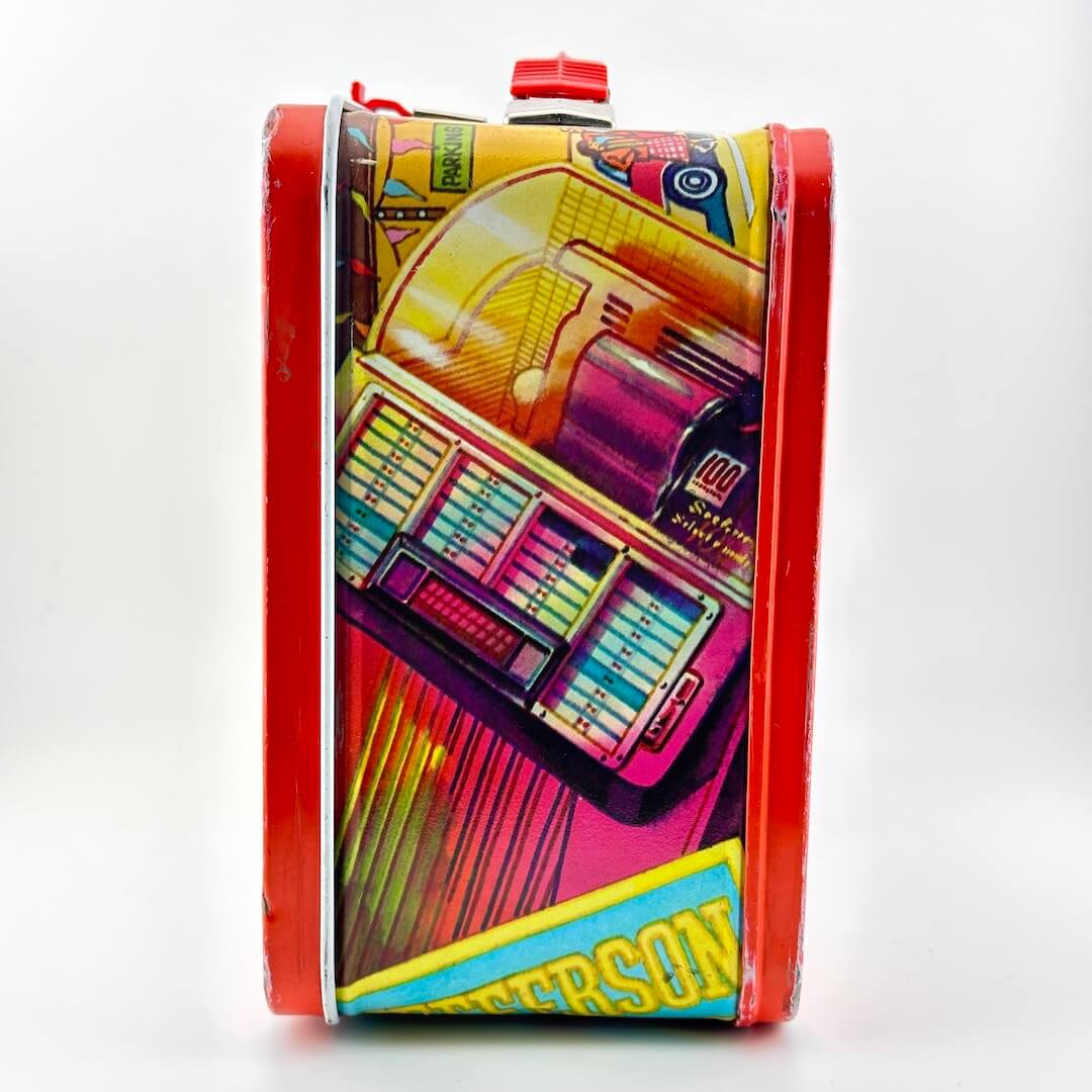 Side view of metal lunchbox with jukebox illustration in bright colors. 
