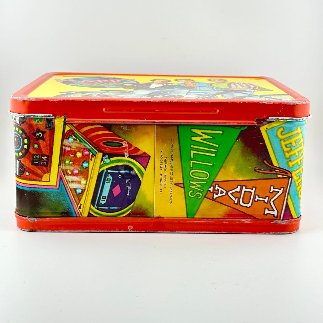 Bottom side of vintage metal lunchbox with red border and brightly colored images from show. 