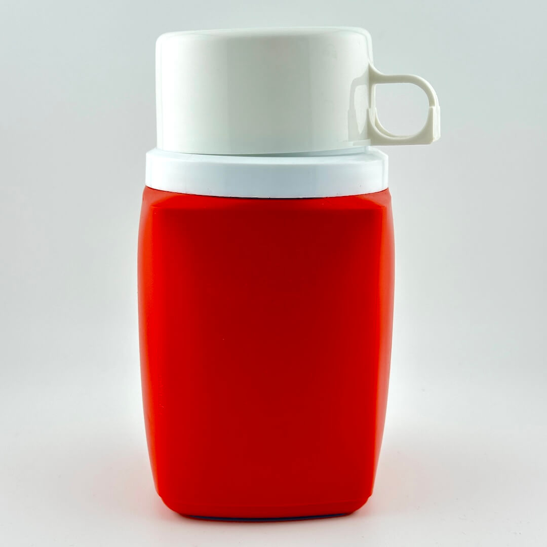 Red and white thermos photographed on white background. 