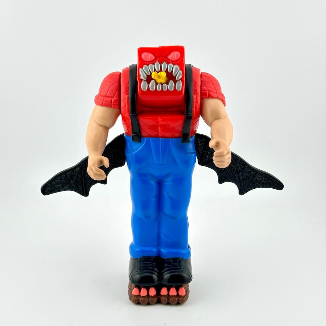 Toy figure with red top, blue pants, and black wings on a white background