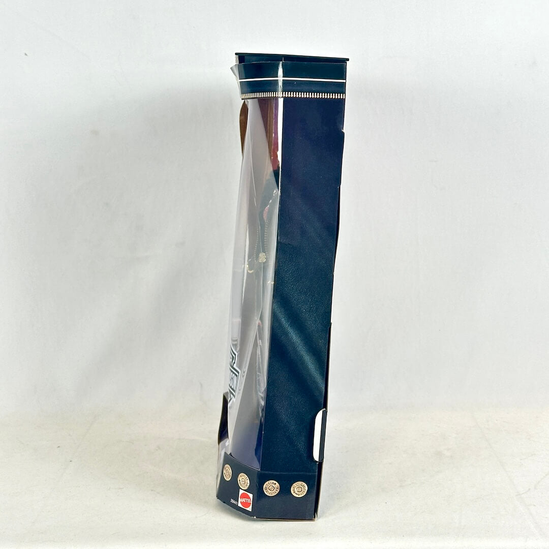 Side view of Barbie packaging on white background. 