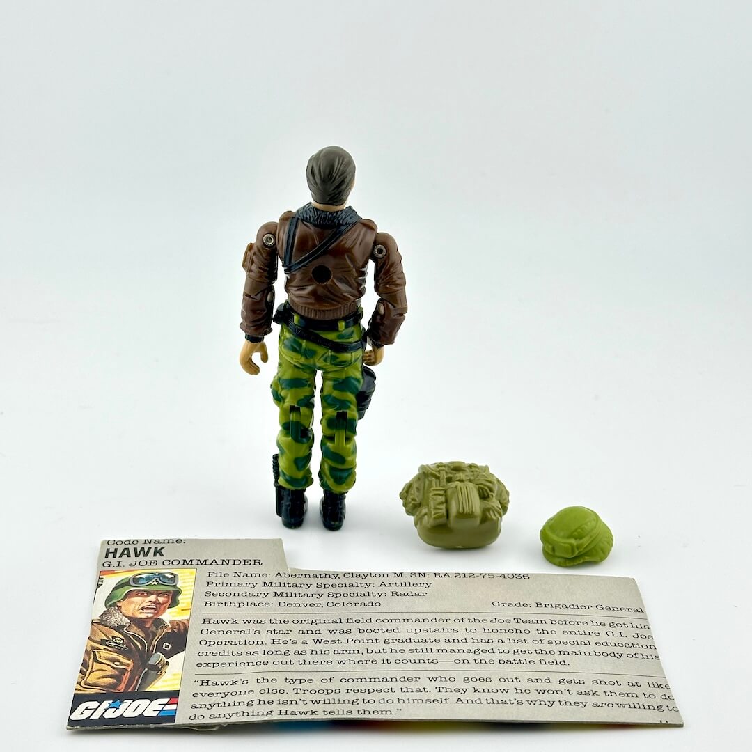 Toy figure of a character from G.I. Joe with accessories and character card on a white background