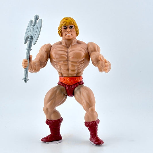 Action figure with red shorts and red boots holding a silver weapon on a white background