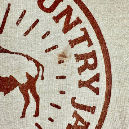 Close-up of a beige canvas-like fabric with a distressed brown stamped bull silhouette and partial text reading "JAYMA.
