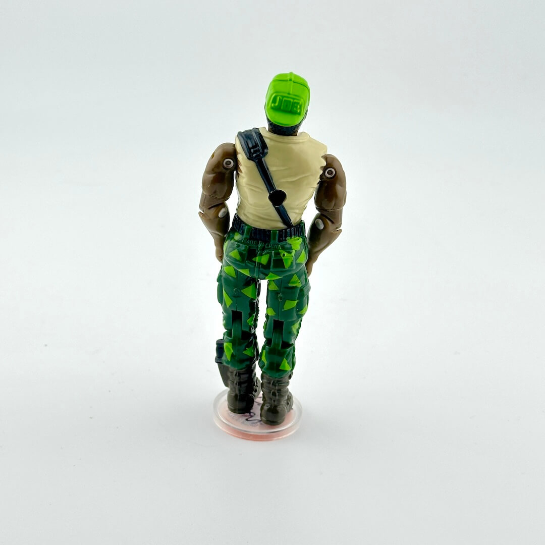 Action figure with green and black patterned pants on a white background