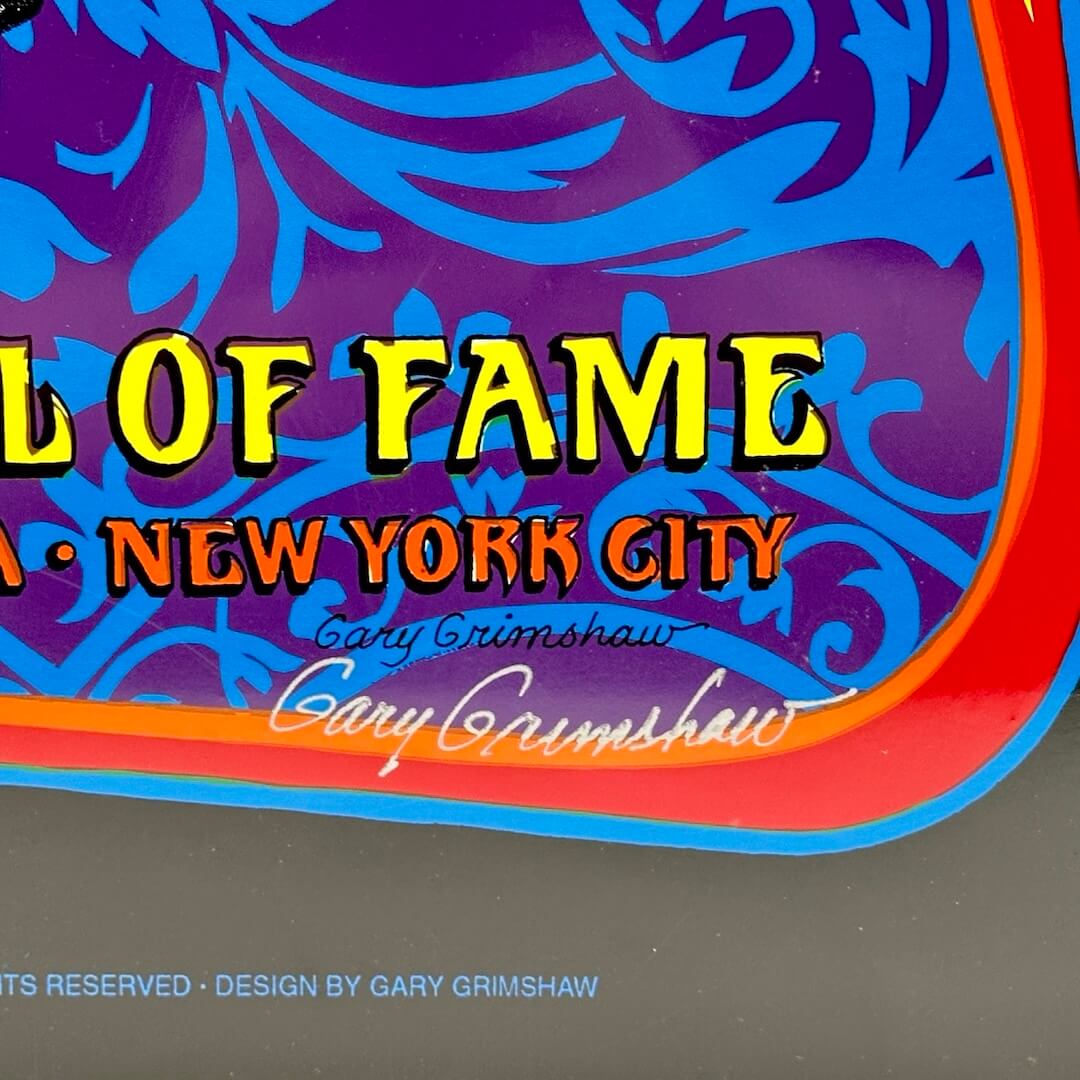 Close up of artist signature in silver marker at bottom right corner.
