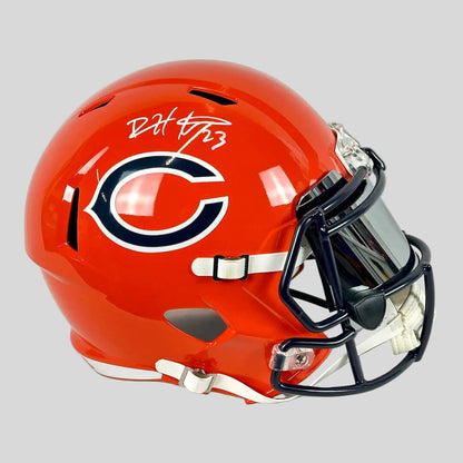 Orange football helmet with a logo and signature on a light gray background