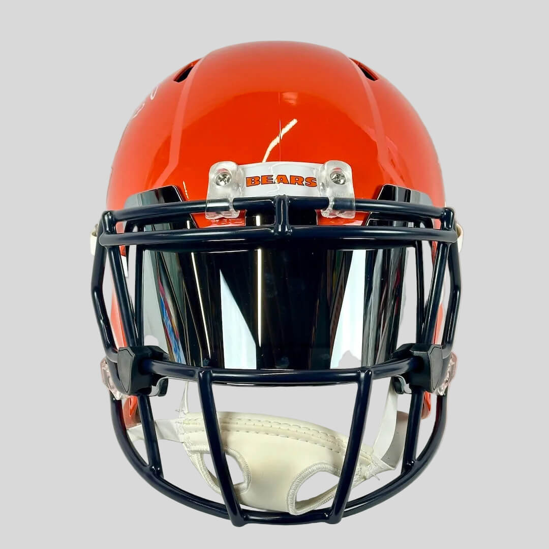 Orange football helmet with black face mask on a white background