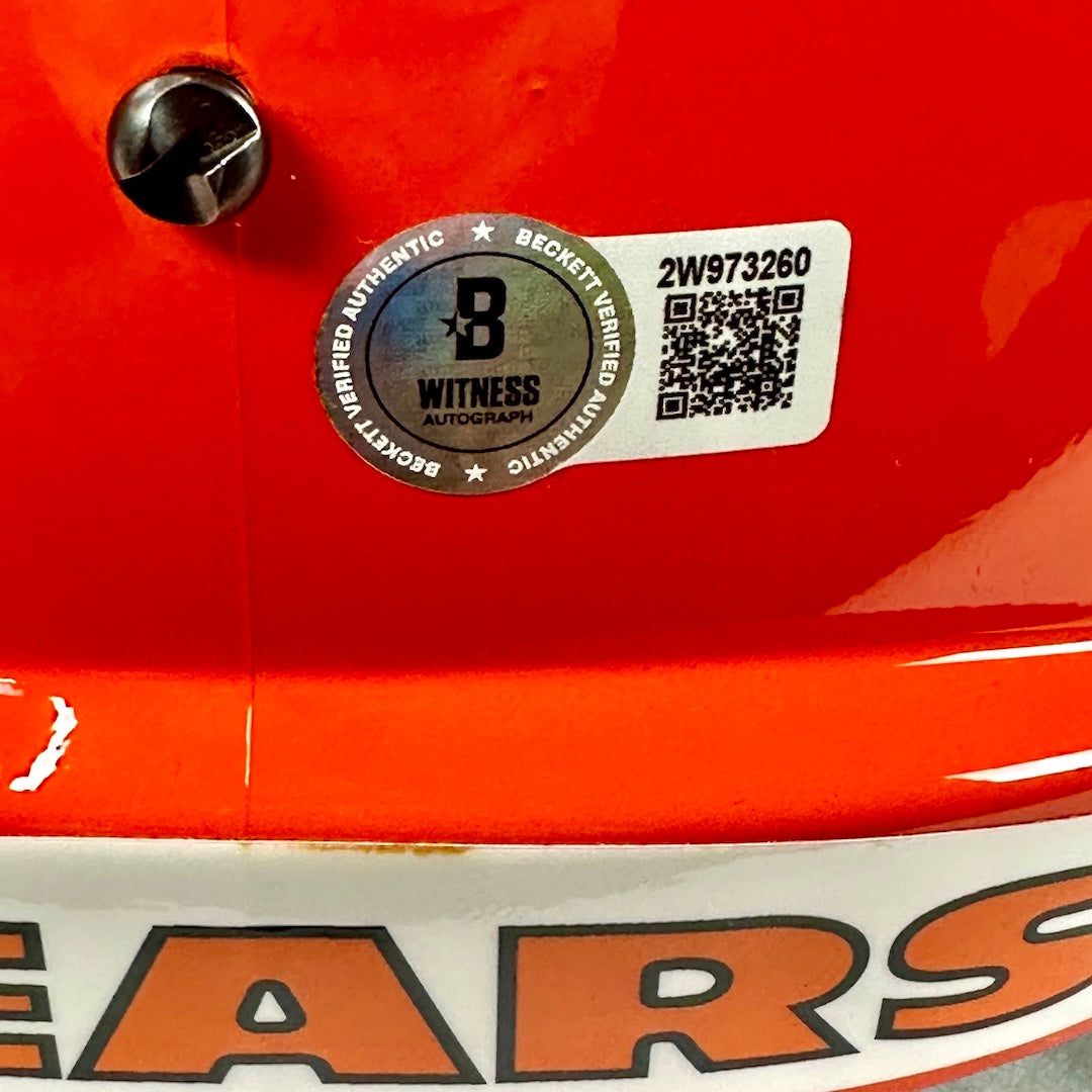 Close-up of a orange object with a label featuring a QR code and text on a white background.