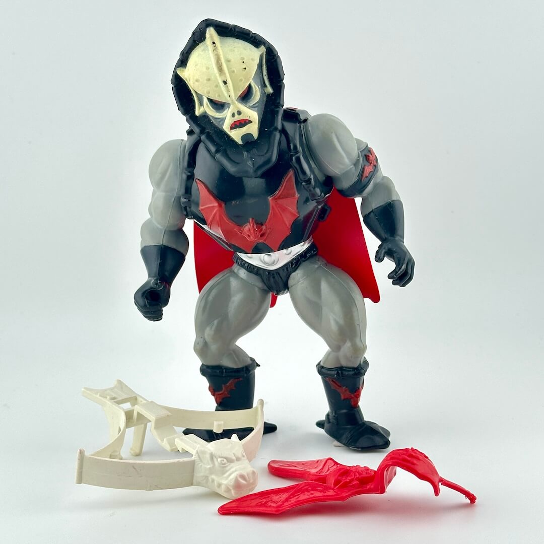 Toy figure with a hooded costume and red cape on a white background