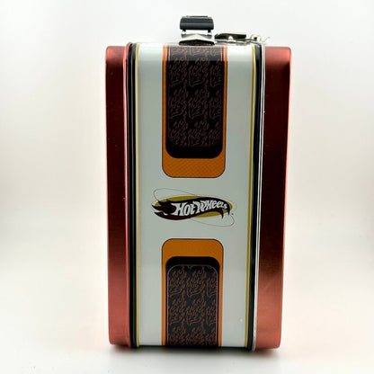 A vintage Hot Wheels metal lunchbox with a flame pattern, featuring a white center with orange and black flame designs.