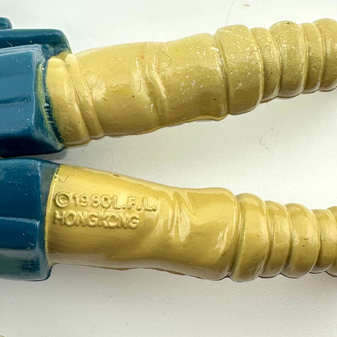 Close-up of COO and copyright information embossed on back of action figure's leg. 