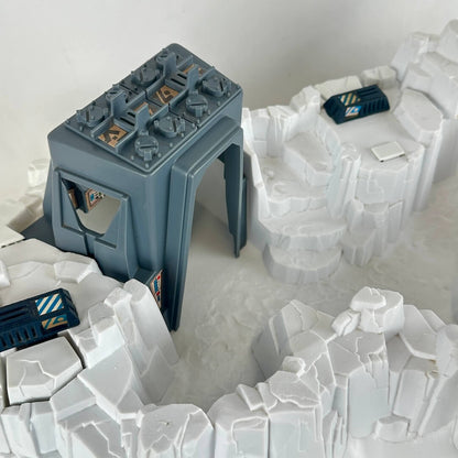 Model of a snowscape military base with buildings and guns on a plain background