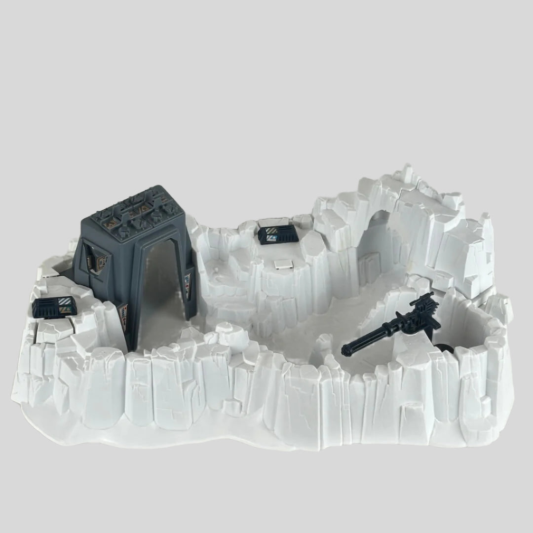 Model of a snowscape military base with buildings and guns on a plain background