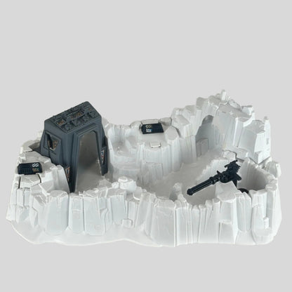Model of a snowscape military base with buildings and guns on a plain background