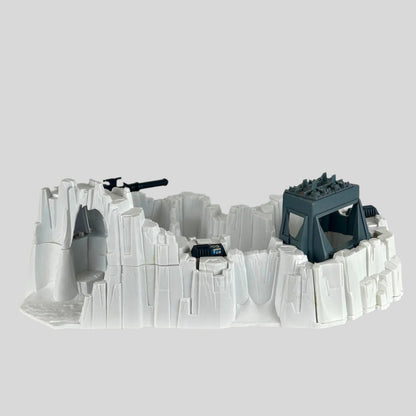 Model of a snowscape military base with buildings and guns on a plain background