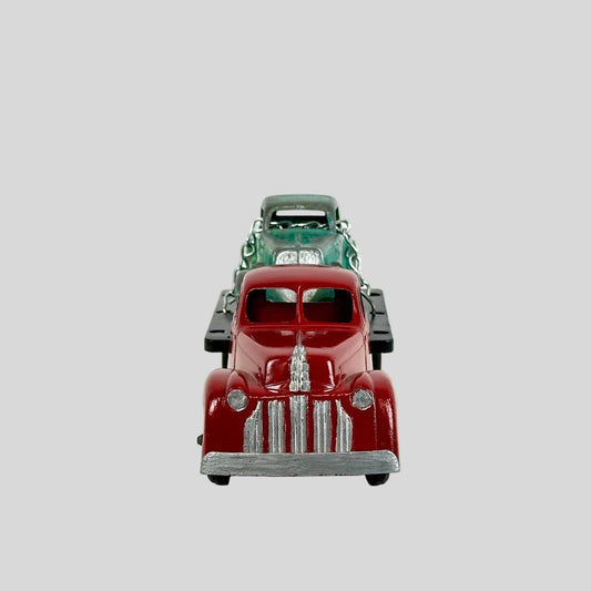 Model of a vintage red truck with a green Christmas tree on a white background