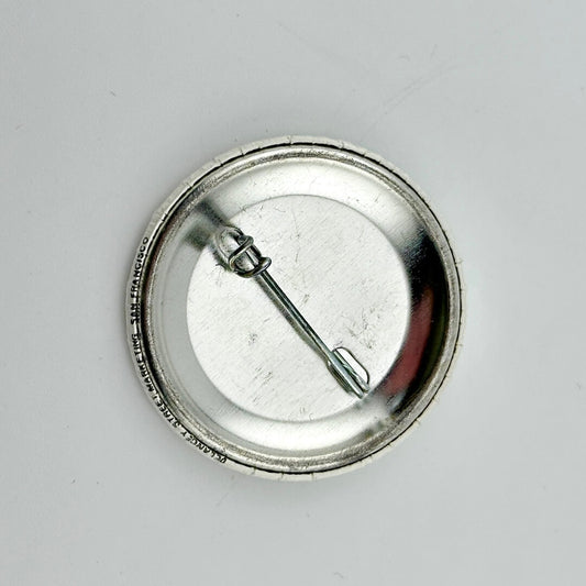 Backside of button against gray background. 