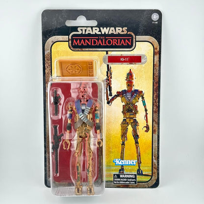 Star Wars The Mandalorian IG-11 action figure in its original blister card packaging, featuring the gold and red droid figure.