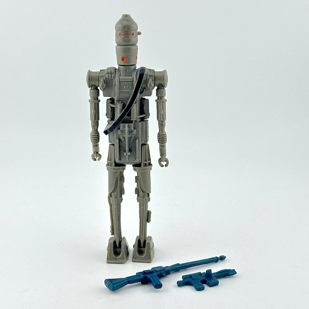 Toy robot figure with blue weapons on a white background.