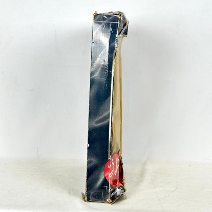 Side view of black Barbie box with discolored plastic on white background. 