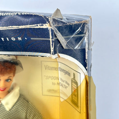 Vintage doll in a box with visible wear and tear on the packaging