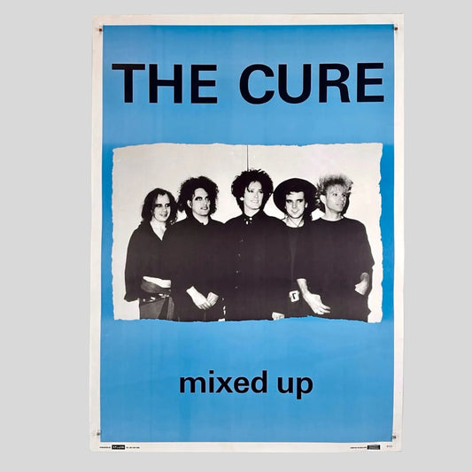 Poster of The Cure with band members and 'mixed up' text on a blue background