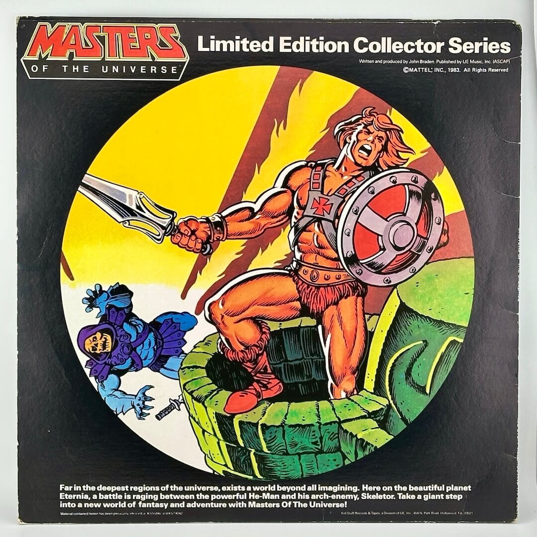 Black record sleeve with window showing picture disc with battle scene between He-Man & Skeletor on yellow background.