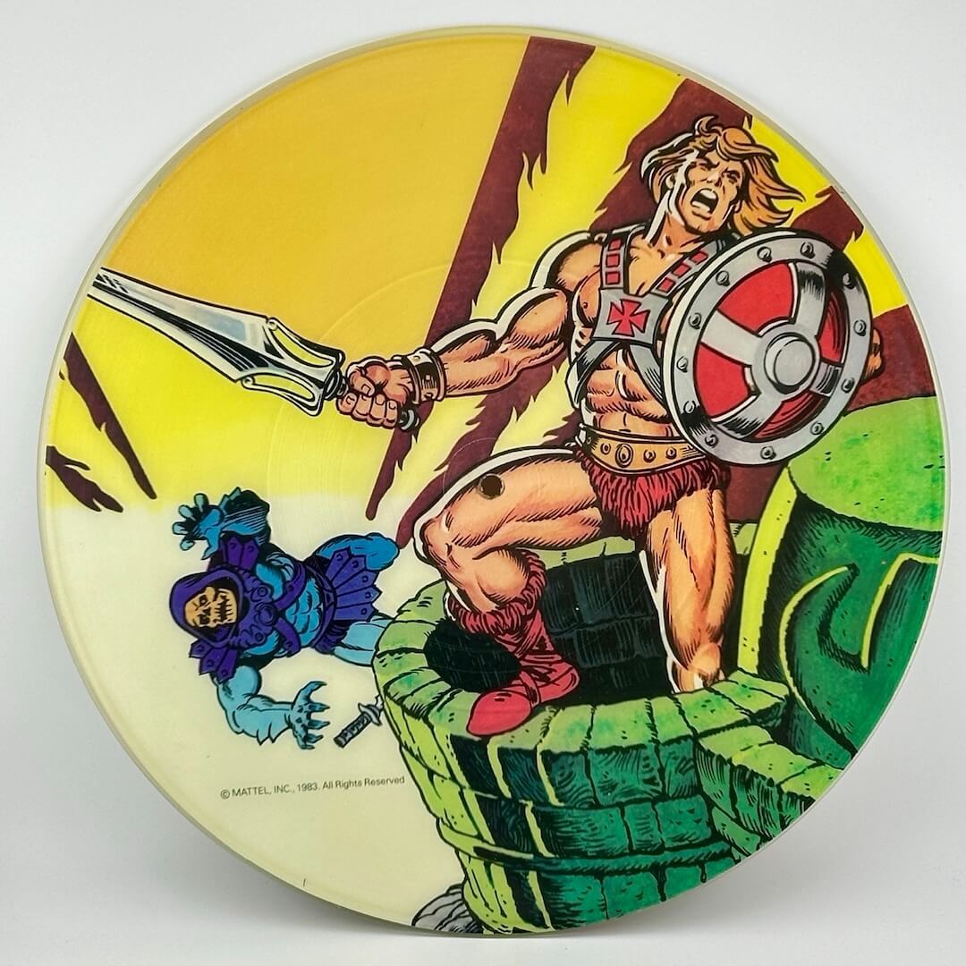 Battle scene between He-Man & Skeletor in iconic outfits on castle tower with Skeletor falling on yellow background.