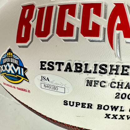 Close-up of a 'Buccaneers' sports memorabilia plaque with Super Bowl XXXVII logo and JSA certification.