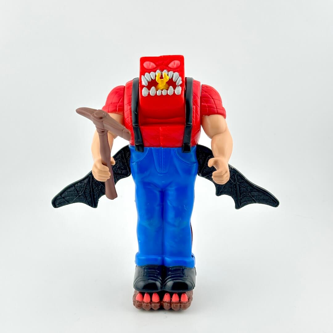 Toy figure with red shirt, blue overalls, and bat wings on a white background