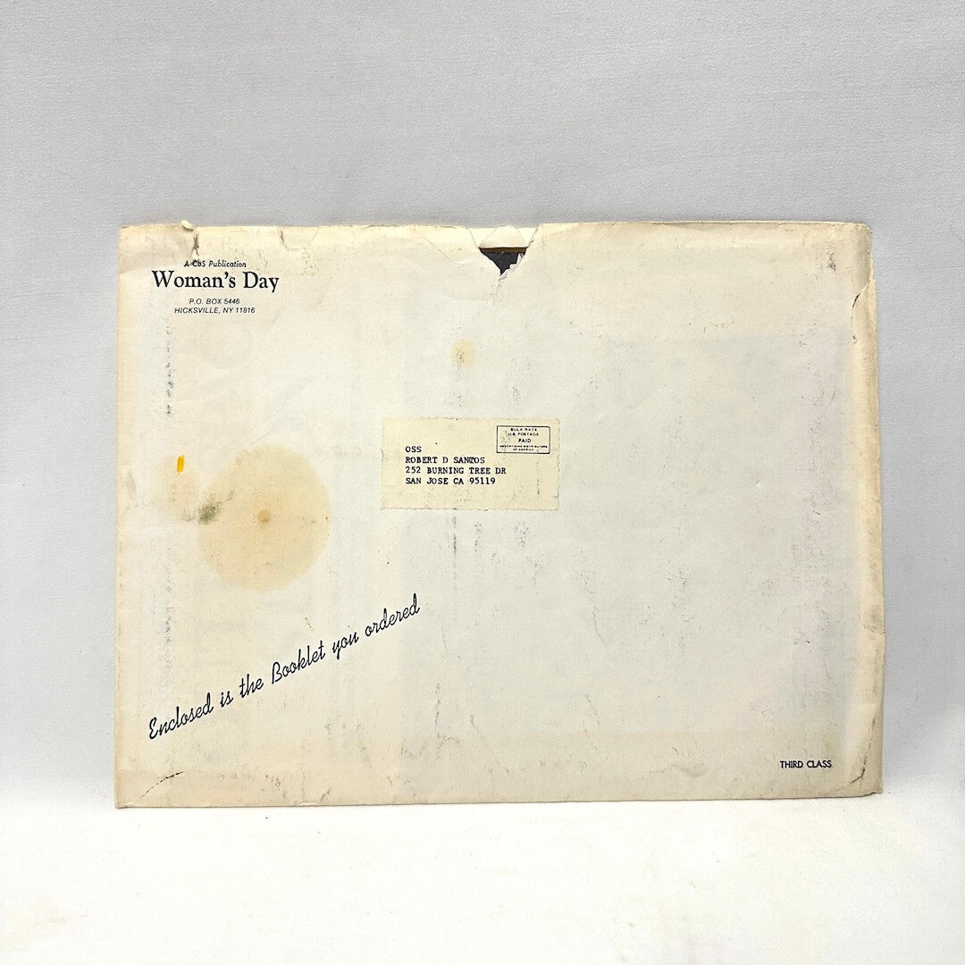 Vintage envelope with 'Woman's Day' label on a gray background
