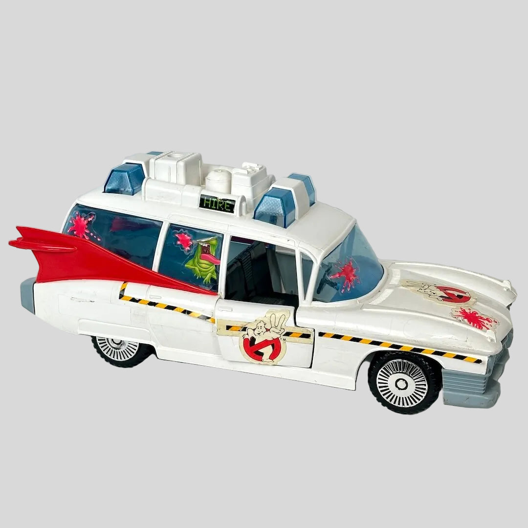Toy vehicle resembling a classic ambulance with a red roof on a light gray background