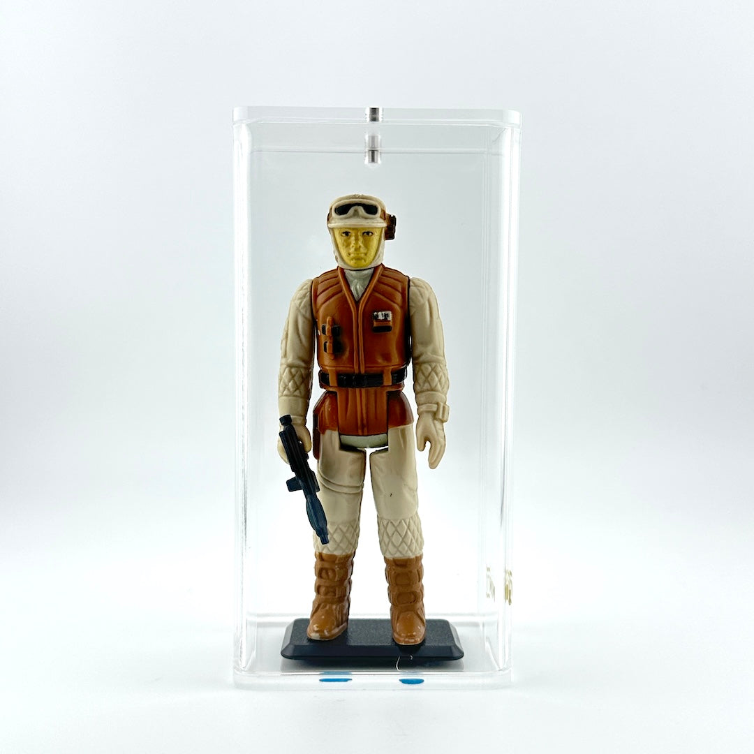 Action figure of soldier in Hoth fatigues holding dark blue gun against white background inside clear display case