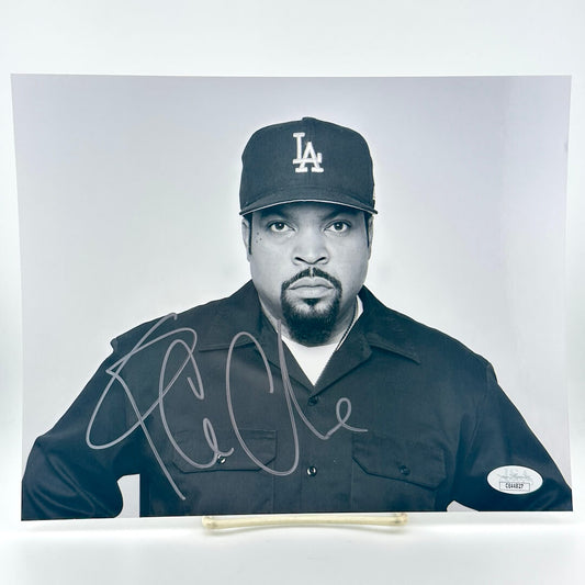 Black and white photo of Ice Cube wearing a cap with a logo, signed on a white background