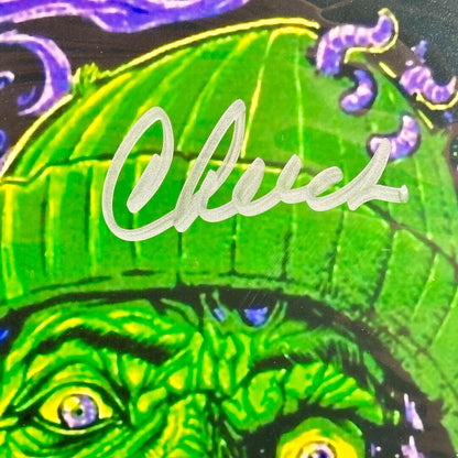Close-up of a green creature with a hat and 'Cheech' signature in silver marker across hat.